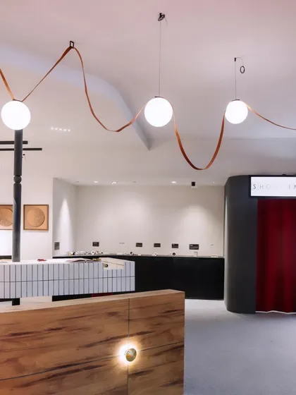 The reception area of our 'ShowTime' booth, featuring globe pendants and custom wall lighting. The design focused on creating a memorable brand experience.