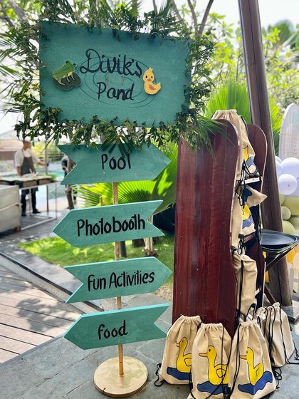 Guiding guests on a fun adventure at Divik's first birthday. This custom-made directional sign points to the pool, photobooth, and other activities, adding a personalized and practical touch to the duck-themed party.