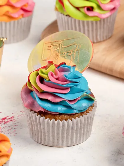 A close-up of a vibrant, multi-colored cupcake for a Holi-themed shoot. The bright colors and fun design perfectly capture the festive spirit.