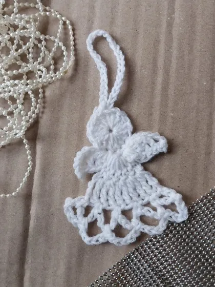 A tiny crochet angel ornament for your Christmas tree.