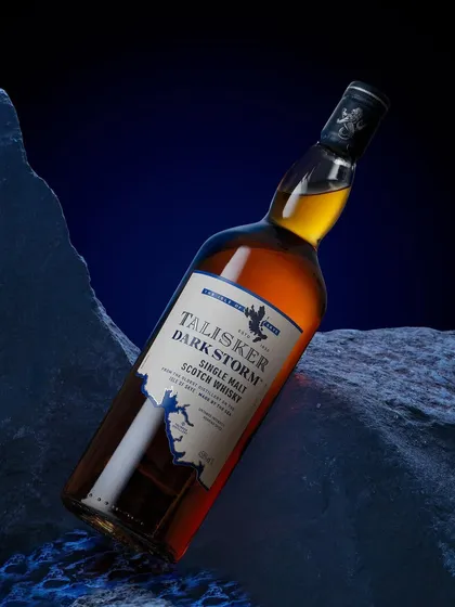 Talisker is "made by the sea," so I created this minimal set with dark, jagged rocks and a deep blue background to evoke a stormy coastline. The angled bottle adds a sense of drama and dynamism.