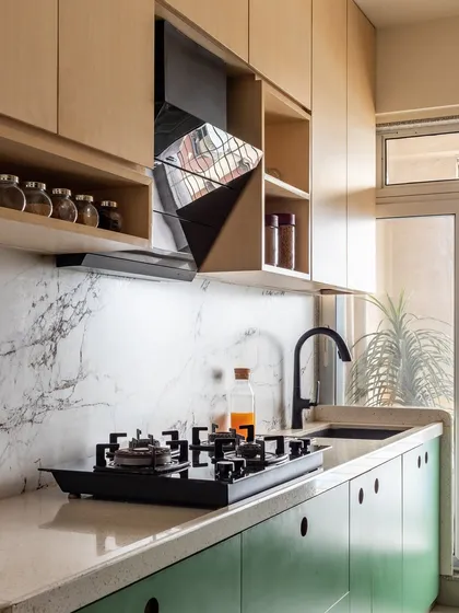 The kitchen is both beautiful and functional, with a marble-patterned backsplash, a modern chimney, and plenty of storage.