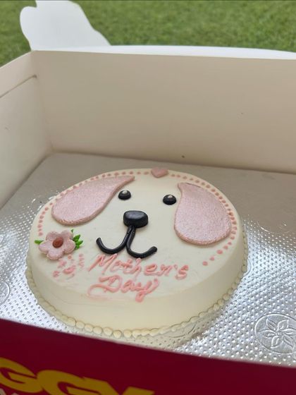 A different angle of our pretty pink Mother's Day cake, featuring a cute dog face and flower details.