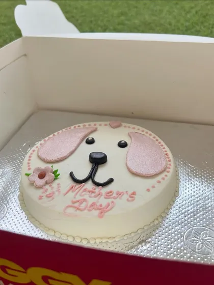 A different angle of our pretty pink Mother's Day cake, featuring a cute dog face and flower details.