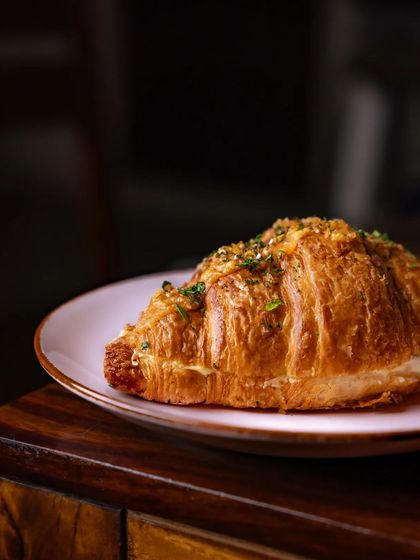 The garlicky aroma of our Garlic Cheese Flaky Croissant fills the crafthouse. It's a golden gateway to a flavorful paradise.
