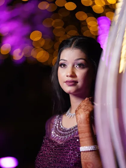 A candid and artistic shot of the bride. The purple lighting highlights the beautiful shimmer on her eyelids.