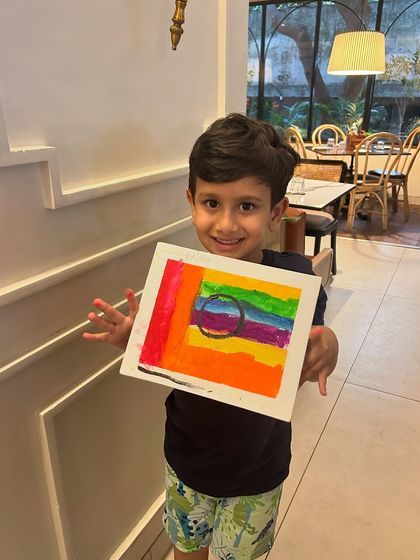 Our little master showing off his amazing abstract rainbow artwork. It's pure joy to see kids express themselves with color at my birthday parties.