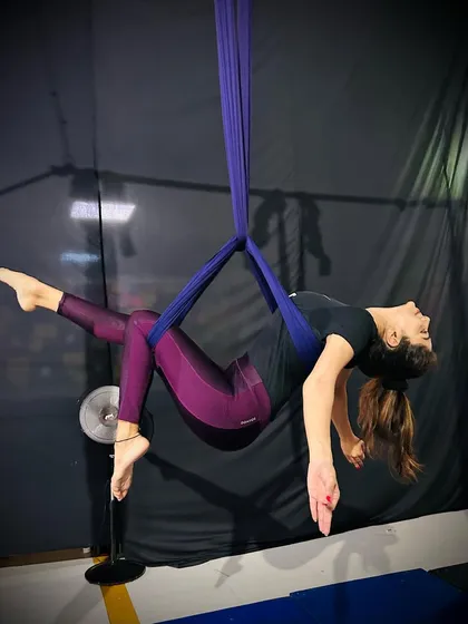 Relaxing into a pose, this student shows how the silks can support the body in gentle backbends and stretches.
