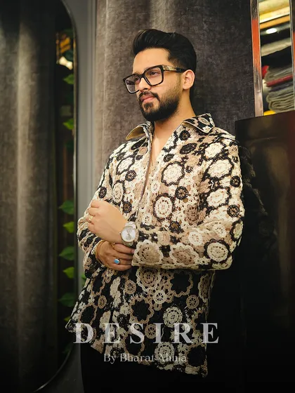 A confident pose in the crochet-style shirt, a piece that is both fashion-forward and effortlessly cool.