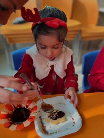 A close-up of an instructor helping a student with her cookie.