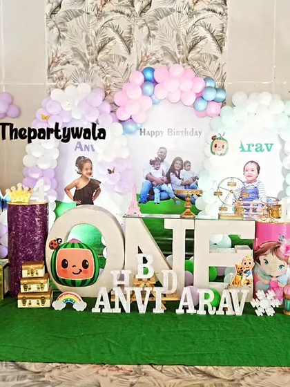 Another view of the large Cocomelon setup, showing the twin birthday photos on the backdrop. I can customize the decor for twins or siblings.