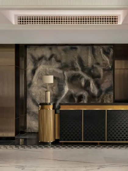 The reception area is designed as a complete sensory experience. A custom sculptural wall evokes the Himalayan landscape, while bespoke furniture and lighting create a sense of refined comfort, grounding the space in both place and purpose.