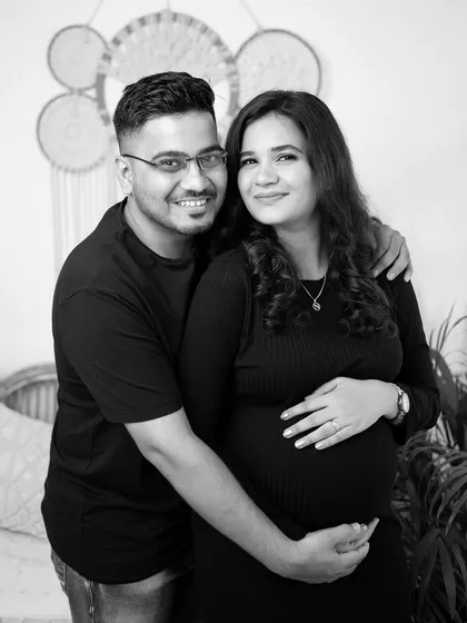 A happy black and white couple's portrait. Their comfortable pose and direct gaze at the camera make for a warm and inviting photograph.