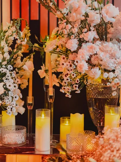 A close-up of the candle and floral decor, where the warm glow of candlelight creates an inviting and romantic atmosphere.