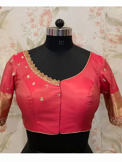 A simple yet elegant red blouse with a cutwork-style embroidered neckline and small buttis scattered across the body.