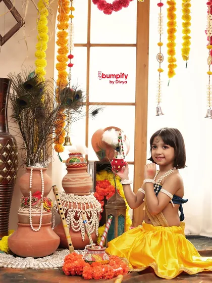 My choti si Radha, looking absolutely radiant in her yellow lehenga. I love creating these playful portraits, complete with props like a dandiya stick, to capture the joyful spirit of Janmashtami.