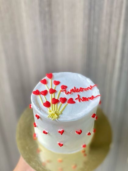 A simple and sweet "Welcome Home" vanilla cake, decorated with a balloon bouquet made of tiny hearts.