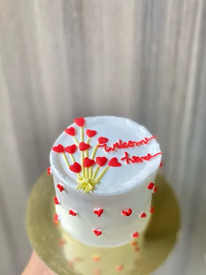 A simple and sweet "Welcome Home" vanilla cake, decorated with a balloon bouquet made of tiny hearts.