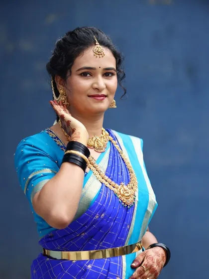 A beautiful portrait of Manasa, ready for her event. I created a classic look with a bold blue saree, traditional gold jewelry, and a simple, elegant updo.