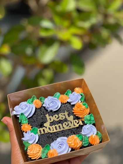 A mini brownie box decorated with colorful frosting flowers and a "best mom ever" topper. A cute and personal gift.