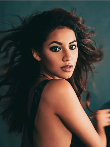 A portrait focusing on the model's expression, with her windswept hair adding to the dynamic feel of the shot. The styling is minimal to let the mood take center stage.