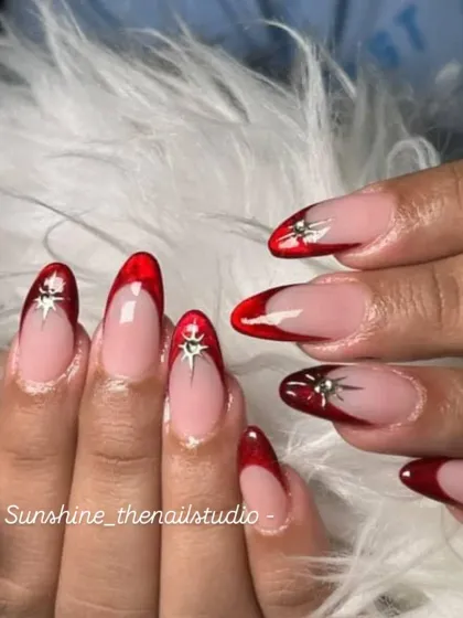 A bold and glossy look. This set features a deep red "jelly" French tip on a clear base, with a silver chrome star for a pop of detail.