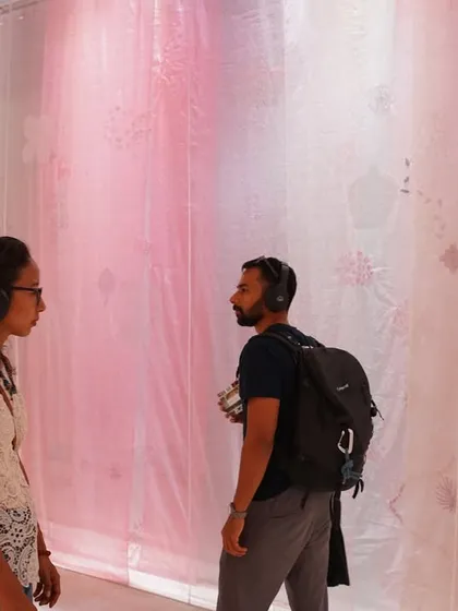 Visitors engage with the 'Feel More' installation, wearing headphones to fully immerse themselves in the audio-visual experience. The space is designed to be a relaxing environment where curiosity is nurtured.