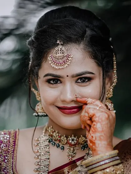 A lovely close-up of Inchara. This shot highlights her beautiful smile and the intricate details of her maang tikka and temple choker.