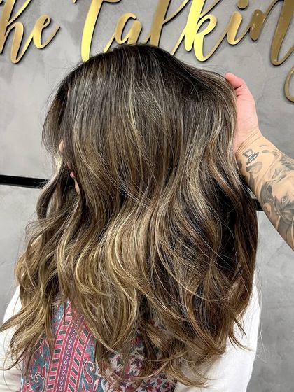 A signature ash blonde balayage, showing the process of foil work and the final, beautifully blended result.