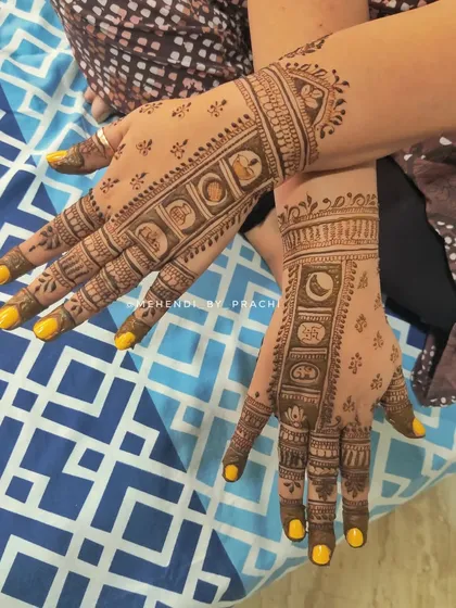This design incorporates all the elements of the Karwa Chauth ritual in small, symbolic blocks along the fingers. It includes the moon, a sieve, and a pot, creating a unique and story-driven mehendi.
