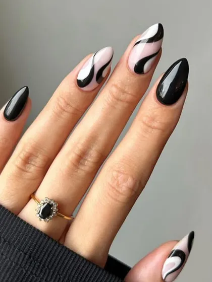 A close-up of the modern black and white abstract swirl design on almond nails.