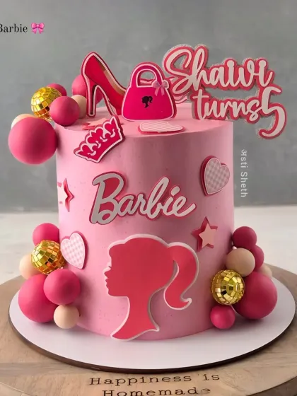A chic and modern Barbie-themed cake in shades of pink. It features a Barbie silhouette, high heel, and handbag toppers for a stylish 5th birthday.