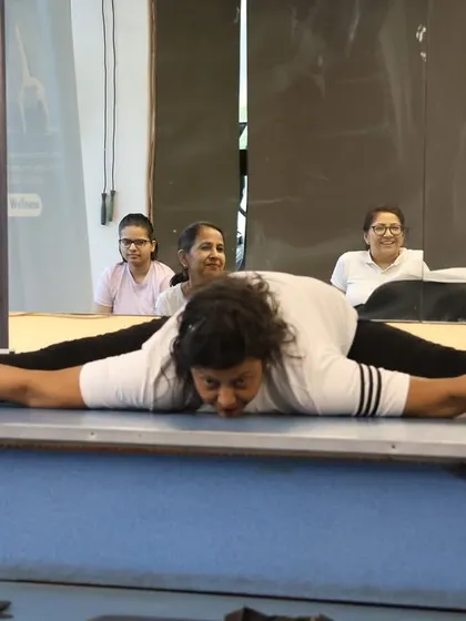This member demonstrates incredible flexibility in a full front split (Samakonasana), a testament to her dedication.