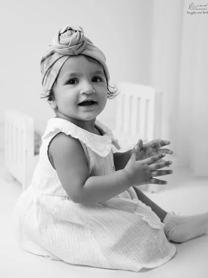 A happy clap. This black and white photo freezes a moment of pure joy and accomplishment for this little one.