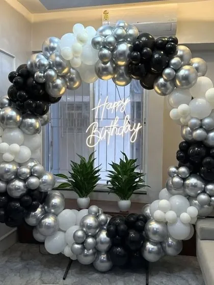 A chic black, white, and silver balloon ring with a neon sign, perfect for a modern home.