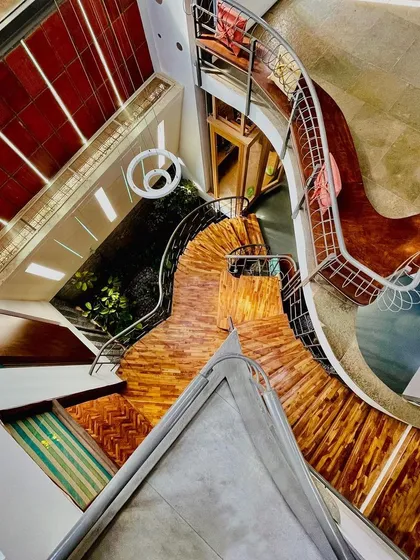 Don't walk, just flow. This top-down perspective of a staircase shows its organic, flowing geometry. The design encourages movement, guided by shifting light and the combination of wood, steel, and stone textures.