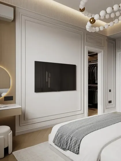 A modern bedroom with a walk-in closet. The design features a TV mounted on a paneled wall and a chic vanity area, blending functionality with high-end style.