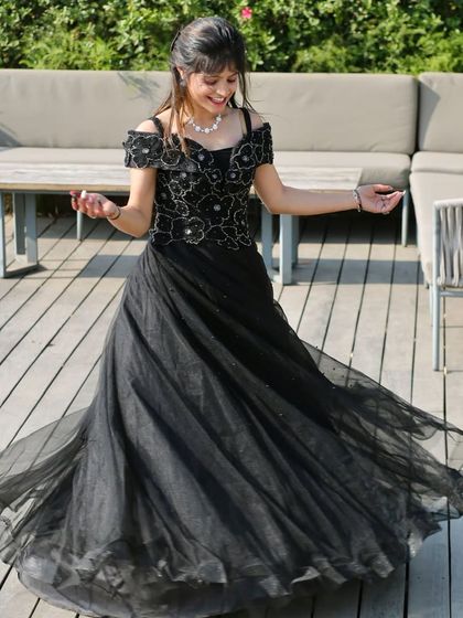A happy twirl in a classic black ball gown. This dress is a versatile and elegant option for any formal celebration.