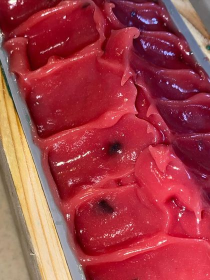 The vibrant, glossy top of our Watermelon soap, complete with "seeds" made from a pinch of black soap batter.
