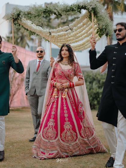 The bride's grand entrance, a powerful and emotional moment as she walks towards the mandap, surrounded by her loved ones.