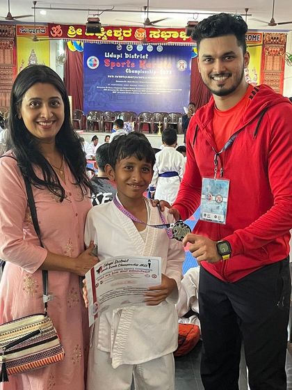 A proud mother joins her son and me to celebrate his medal win at the district championship.