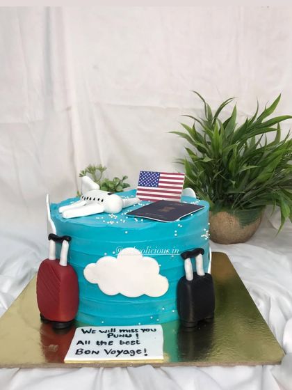 A "Bon Voyage" cake for a farewell party. This travel-themed cake features an airplane, passport, and luggage, wishing the traveler all the best on their journey.