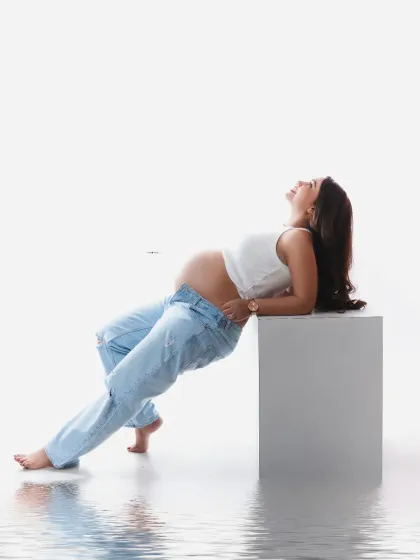 A modern and relaxed pose with a creative twist. The water reflection effect adds an artistic and dreamlike quality to this casual, high-key portrait.