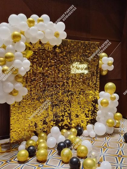 Another view of the popular gold sequin wall with a white and gold balloon arrangement.