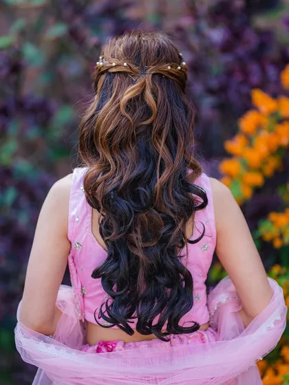 The back view of the modern Haldi hairstyle, featuring a braided crown and soft waves.