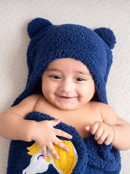 If you missed the newborn window, the 3 month milestone is a perfect time for a photoshoot. At this age, babies have the most adorable giggles and make great eye contact, like this little one in his bear towel.