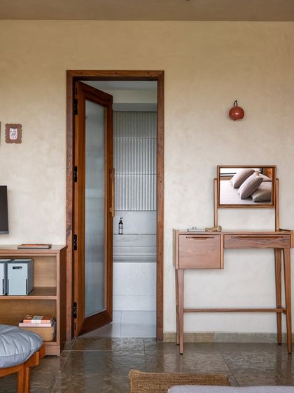 Another view of the master bedroom, showing the custom vanity table and the doorway to the bathroom. The space is designed to be a private, quiet counterpoint to the more social areas of the home.