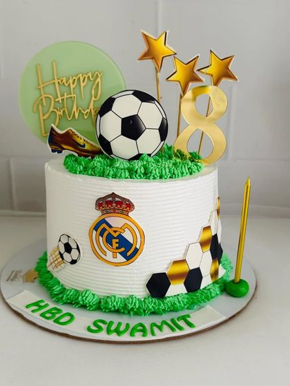Another Real Madrid themed cake, this one with a vibrant green turf effect and gold star accents.