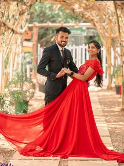 A beautiful portrait in a garden tunnel. The long red trail of the gown creates a stunning visual, leading the eye through the photo.
