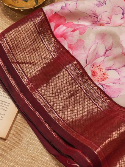 The contrast between the soft floral print and the heavy zari border makes this a unique piece for any celebration.